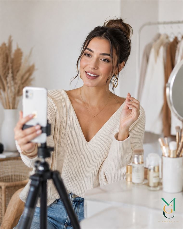 Créatrice filmant une démonstration de produits de beauté au smartphone.